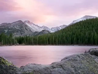 Rocky Mountain National Park, Colorado, USA taken at sunset at Bear Lake, with trees and mountains in the distance.