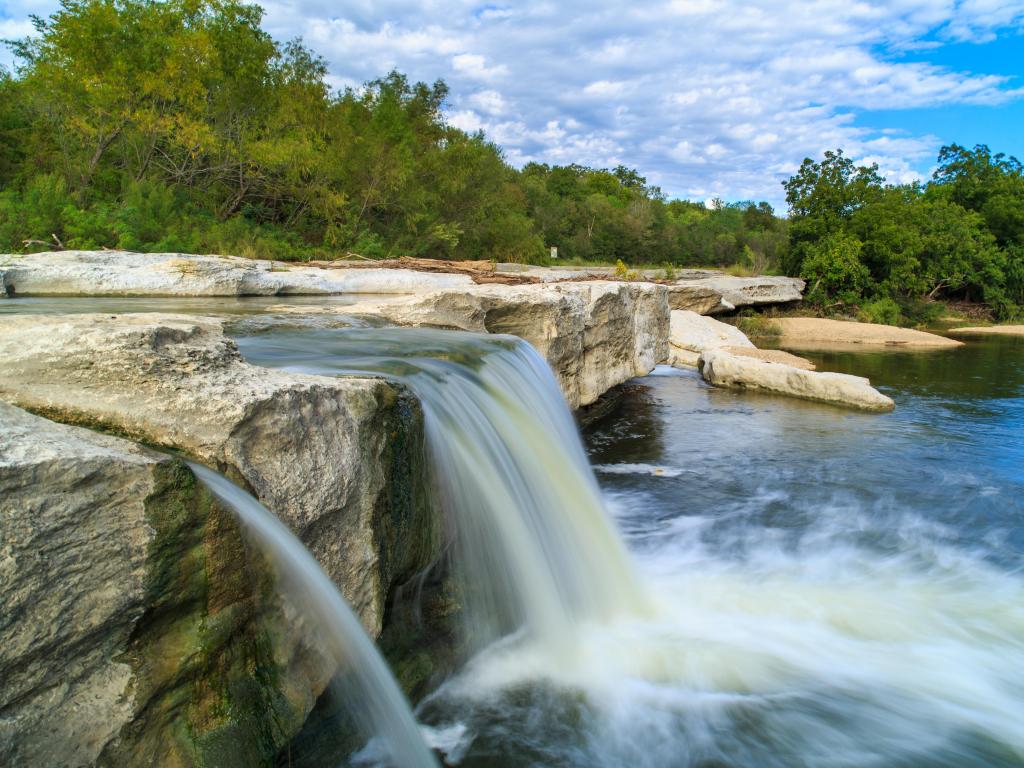 McKinney Falls State Park, Austin, Texas, USA taken at the Lower Falls with trees in the background and taken on a sunny day.