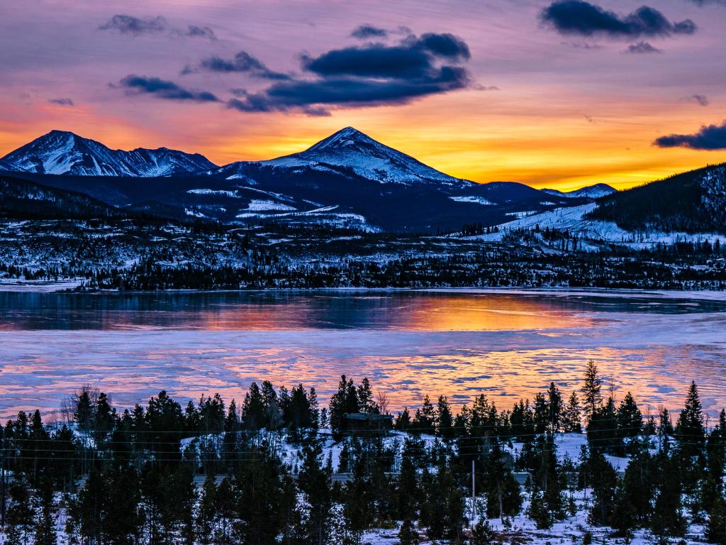 Sunrise over Breckenridge, Colorado, with a purple and orange-hued sky and mountains in background