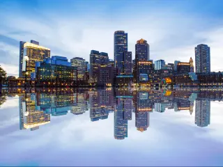Boston, USA with a view of the city skyline from Downtown Harbor walk at dusk and a fantastic reflection of the skyscrapers in the water. 