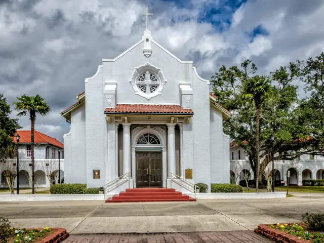White facade of the St. Charles Borromeo Catholic Church on a cloudy day