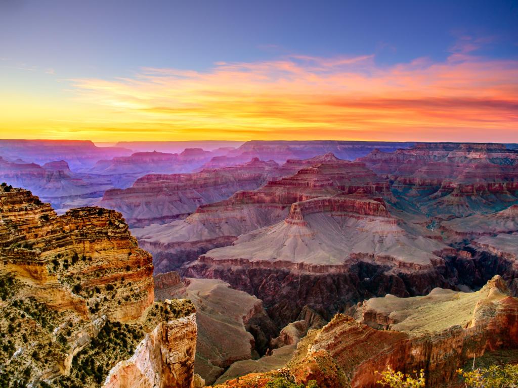 A view of the famous Grand Canyon South Rim at sunset, with a multicolored sky above the vast canyon below