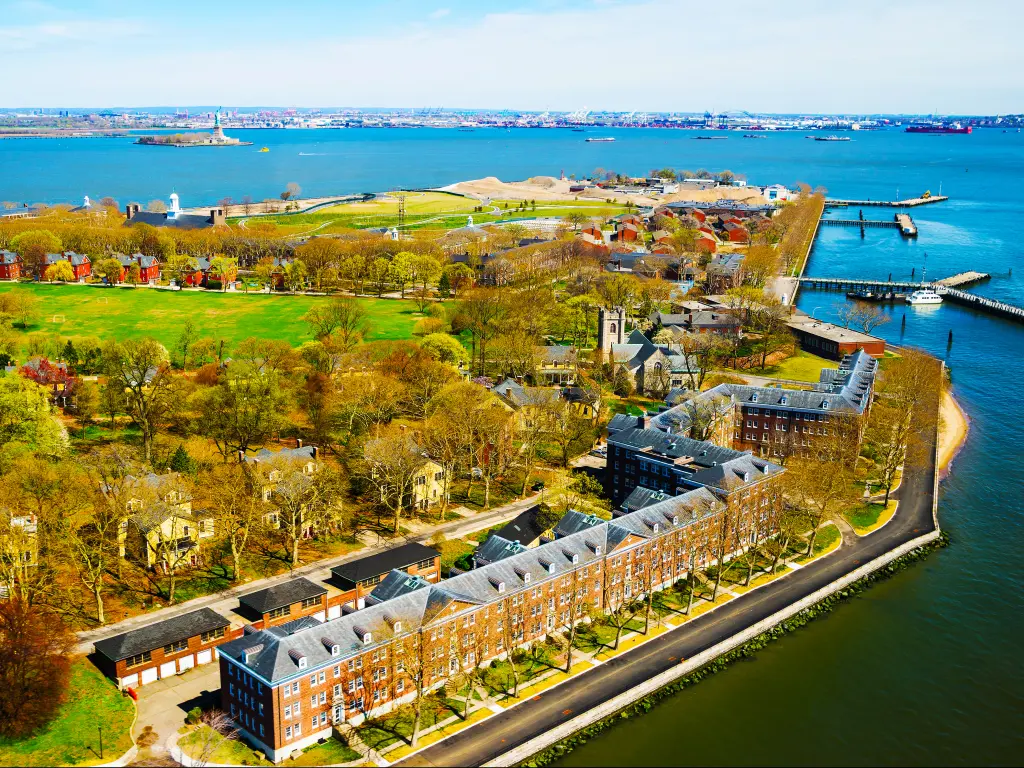 An aerial view of Governors Island in Upper New York Bay with beautiful American Architectural buildings, green fields, and trees, Manhattan area, New York City