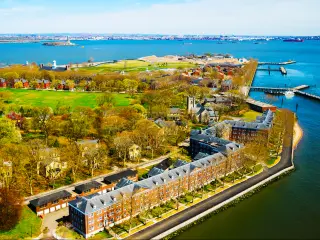 An aerial view of Governors Island in Upper New York Bay with beautiful American Architectural buildings, green fields, and trees, Manhattan area, New York City