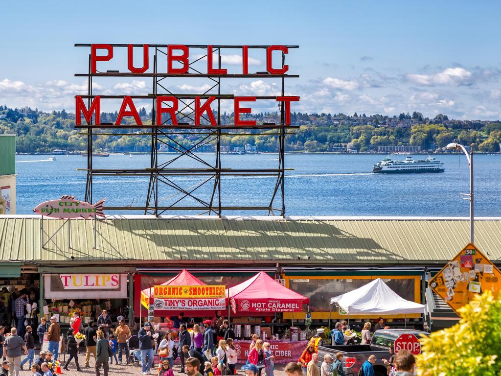 Crowded waterfront public market with a red sigh that says 