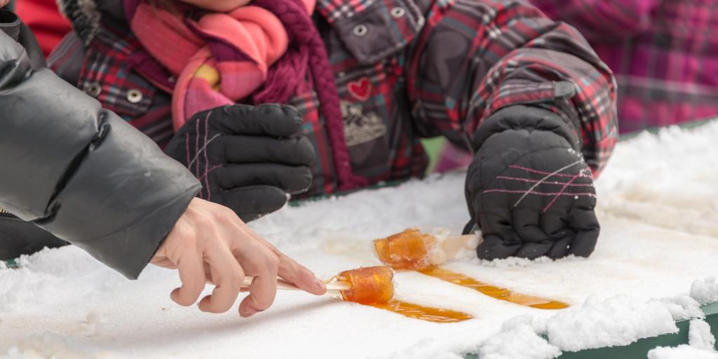 People making maple taffy in the snow in Quebec