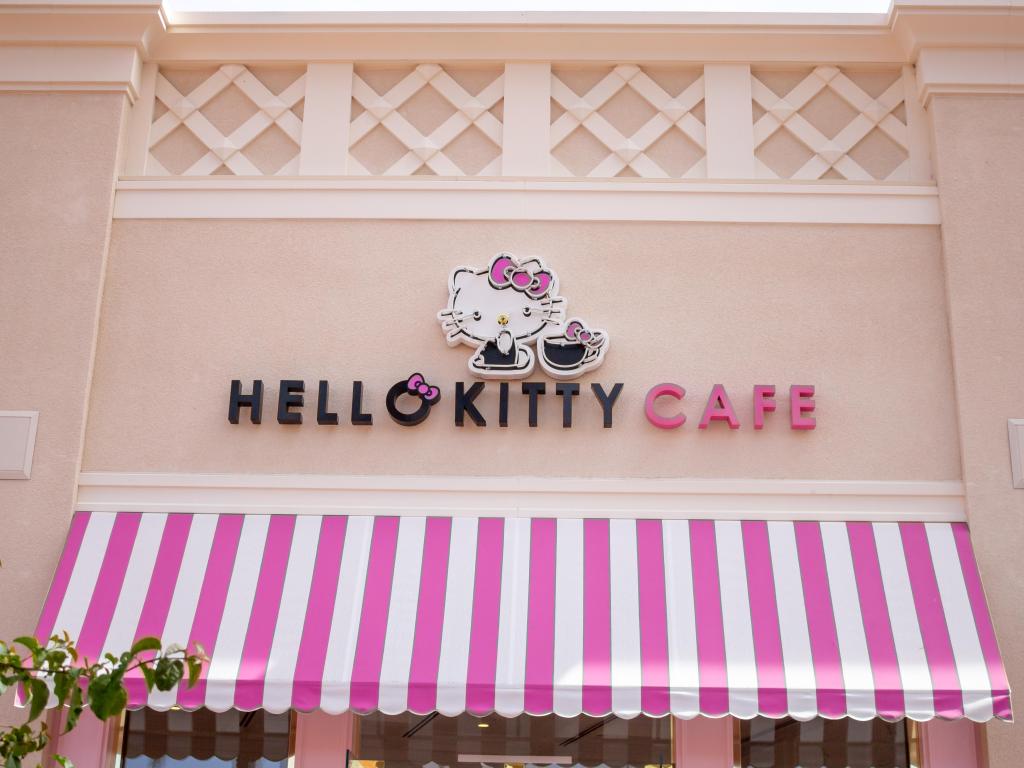 The pink and white string awning of the Hello Kitty Grand Cafe with the store sign above it