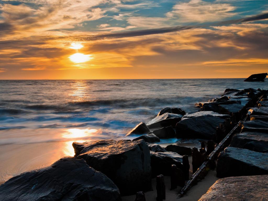 Sunset Beach, Cape May, New Jersey, USA with a sunset over a jetty and the USS Atlantis Shipwreck.