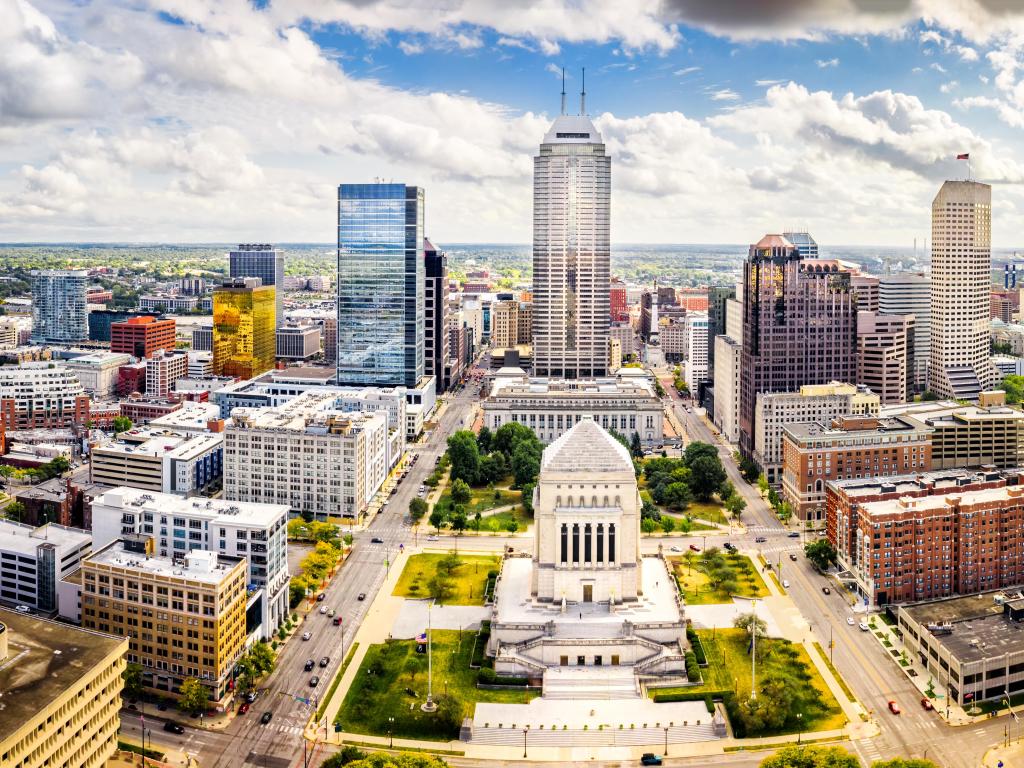 Indianapolis, Indiana, USA taken as an aerial view over the city skyline above Indiana World War Memorial and University park, and along Meridian and Pennsylvania streets on a sunny day.