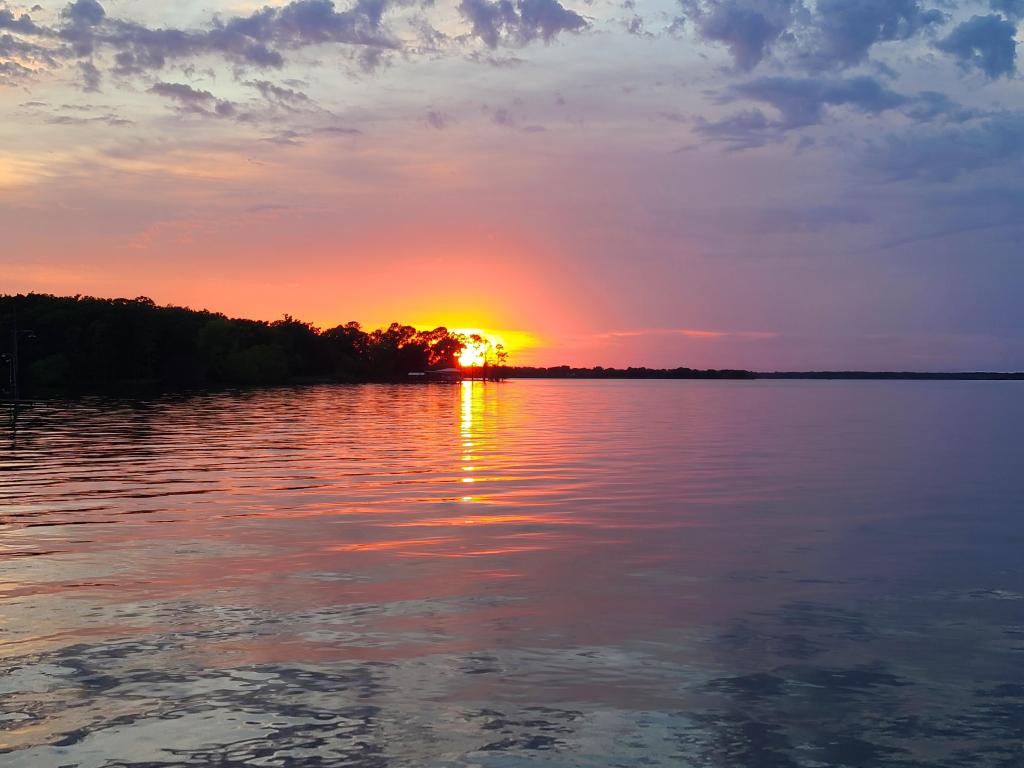 Lake Tawakoni, Texas, USA taken at sunset with trees in the distance.