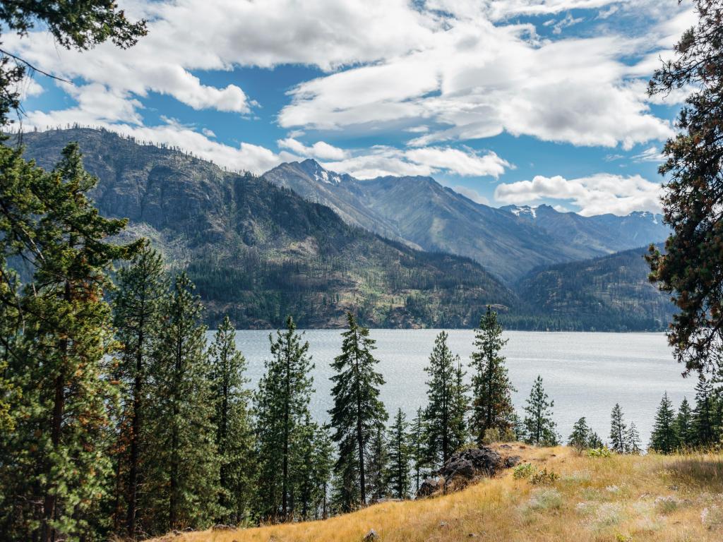 Winter day at Lake Chelan in Washington State, with pine trees surrounding the lake and mountains in the background