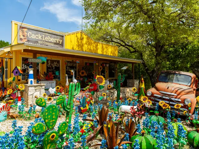 Colorful shop with art and artificial plants and an old pickup truck in Wimberley, Texas.