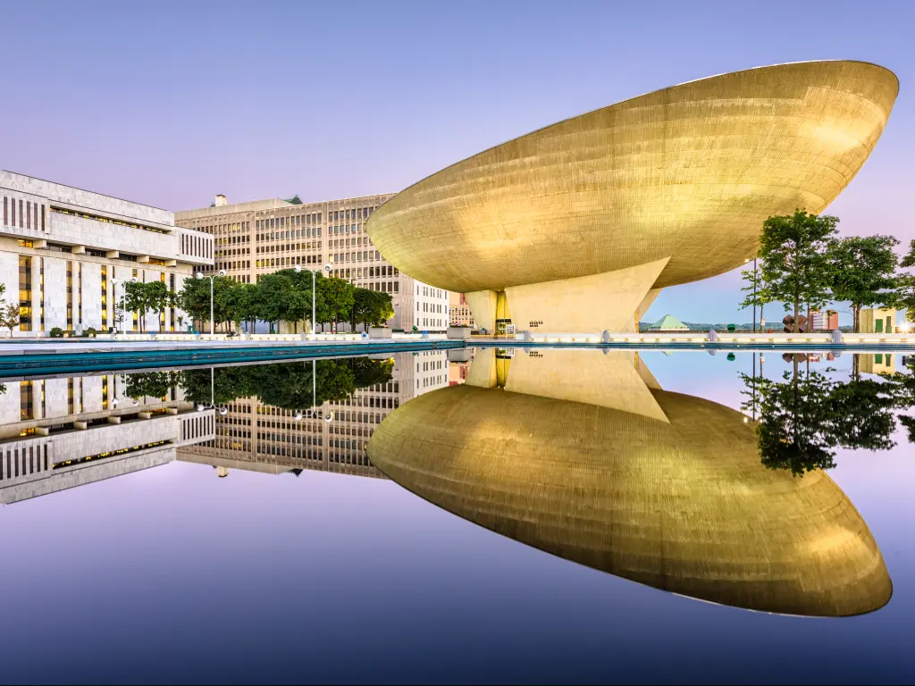 The Empire Plaza at the Egg reflecting from the water on a fine day.