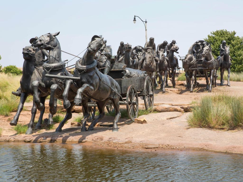 Centennial Land Run Monument in Bricktown, Oklahoma City depicting several horse carriages, horses and men