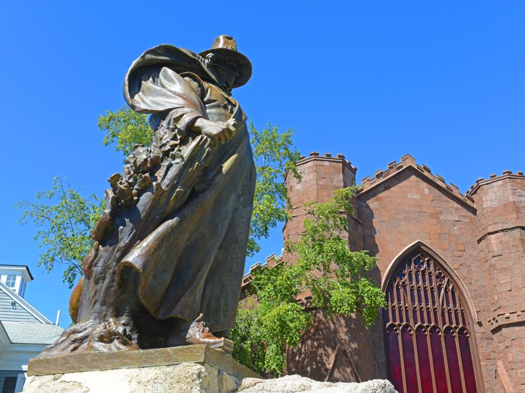 Roger Conant statue in front of Salem Witch Museum on a sunny day, located in Historic downtown