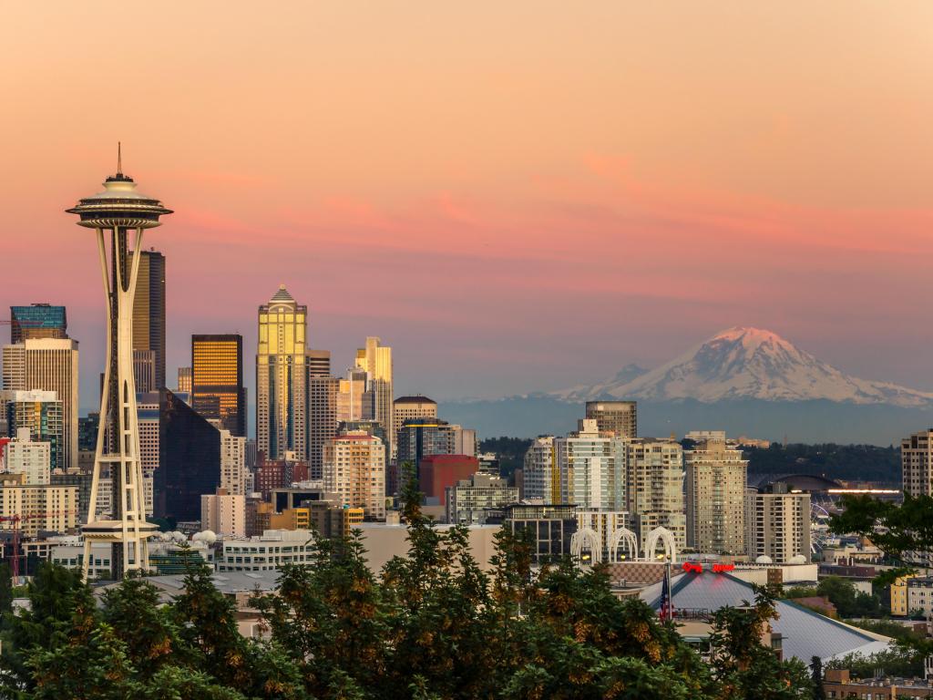 Cityscape with mountain in the background lit up in pink sunset light