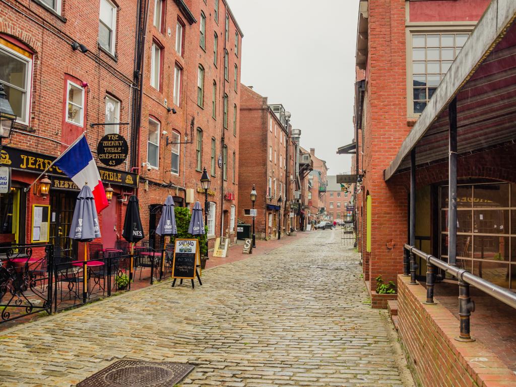 Cobbled streets and brick buildings with bars and restaurants in the Old Port District in Portland, Maine.