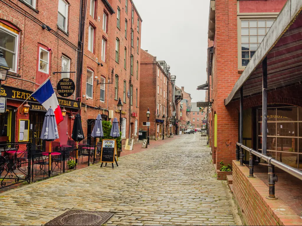 Cobbled streets and brick buildings with bars and restaurants in the Old Port District in Portland, Maine.