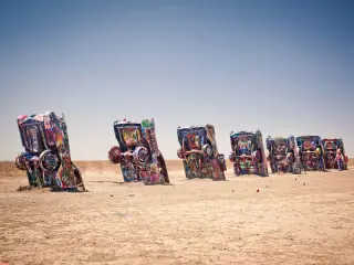 Graffiti-covered Cadillac cars in an art installation, sticking out of the ground in the desert