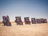 Graffiti-covered Cadillac cars in an art installation, sticking out of the ground in the desert