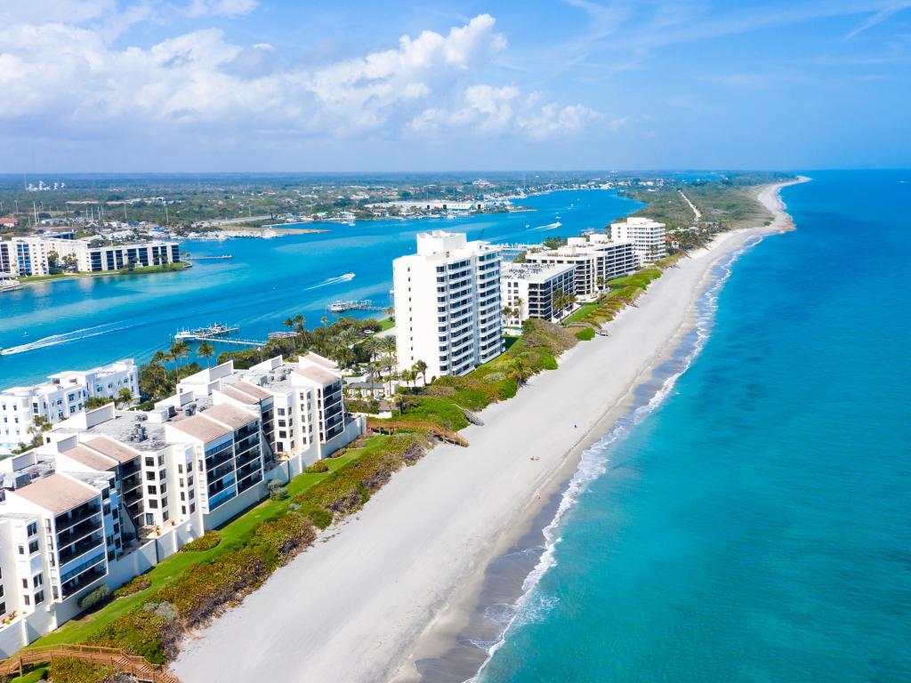 Jupiter Island, Florida, USA with the long coastal beaches along Florida's east coast, white buildings lining the shore and a turquoise blue water surrounding.