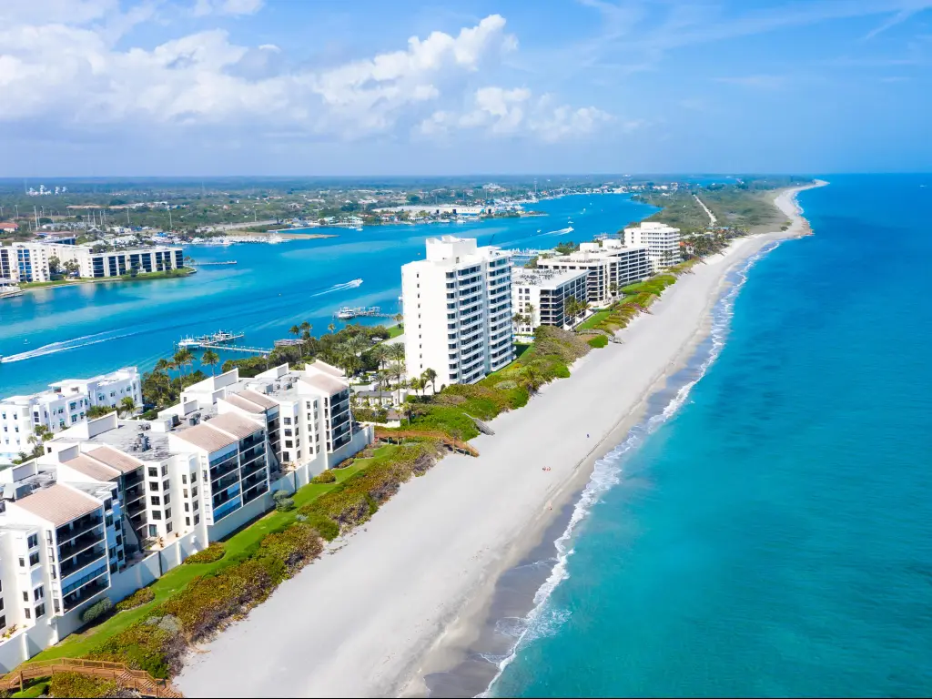 Jupiter Island, Florida, USA with the long coastal beaches along Florida's east coast, white buildings lining the shore and a turquoise blue water surrounding.