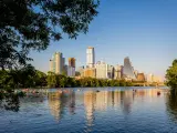 Austin skyline on a clear day and its reflection on Lady Bird Lake, dotted with boaters