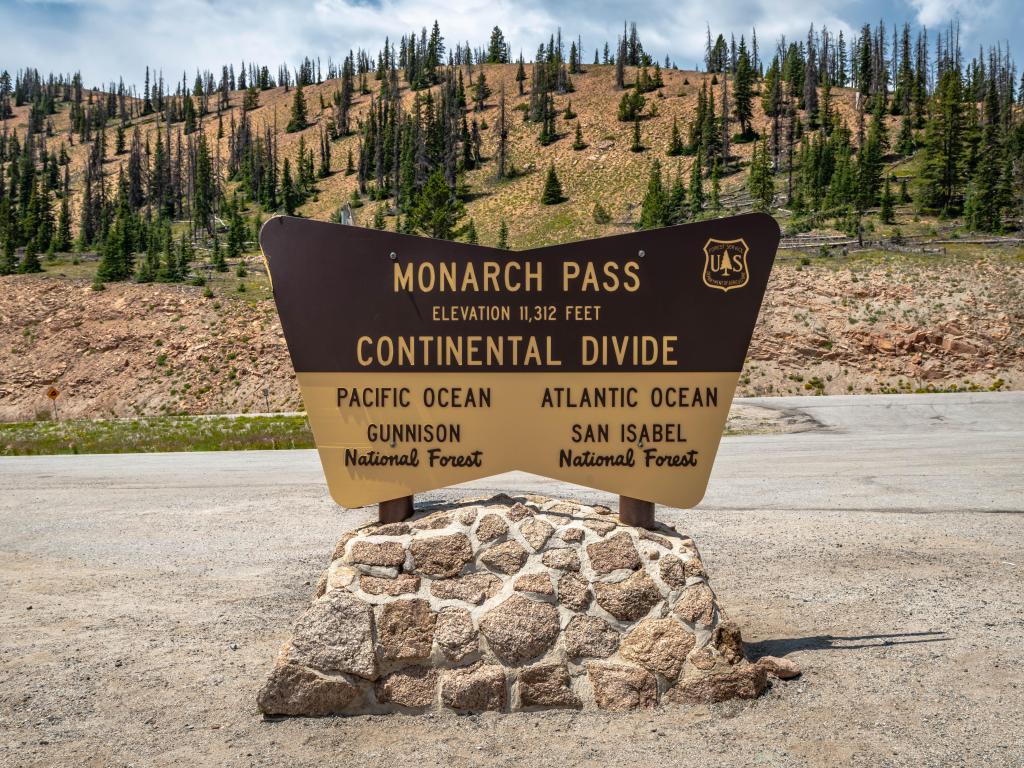 Monarch Pass Continental Divide sign at the side of Route 50 in Colorado, indicating an elevation of 11,312 feet.