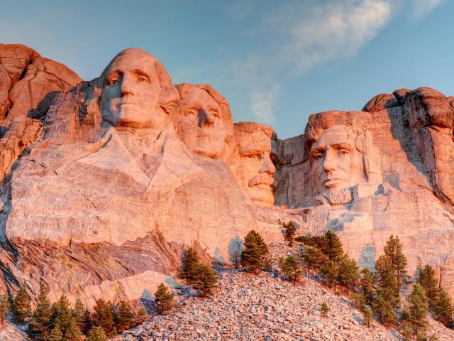 Mount Rushmore National Park in the Black Hills South Dakota during a warm sunrise with clear blue sky morning. 