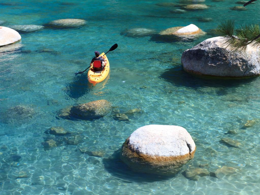 Kayaker on the clear waters of Lake Tahoe, sunny day.