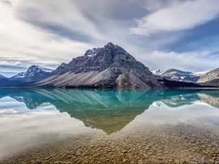 Bow Lake, Banff National Park, Alberta, Canada with reflections in the water of the mountains in the distance.