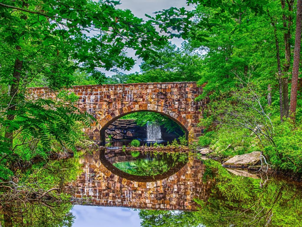 Petit Jean State Park near Russellville, Arizona, USA with a bridge, waterfall and foliage reflections of scenic Davies Bridge.