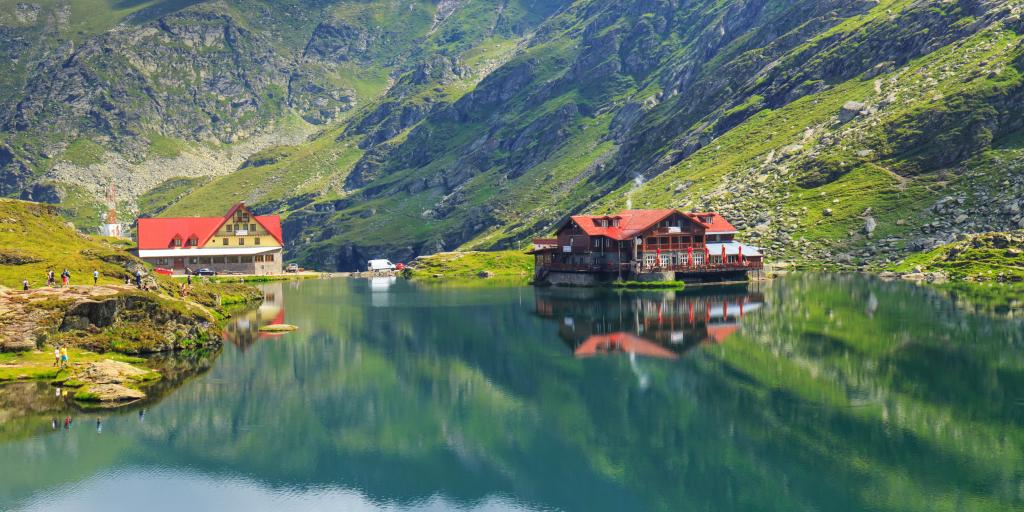 Chalets and mountains reflected on Balea Lake in Romania