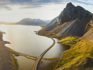 Panoramic aerial view of a scenic road crossing the water and circling islands on the Icelandic coast