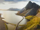 Panoramic aerial view of a scenic road crossing the water and circling islands on the Icelandic coast