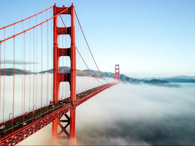 Golden Gate Bridge, San Francisco, California. The photo depicts a sunny day with low clouds under the bridge.