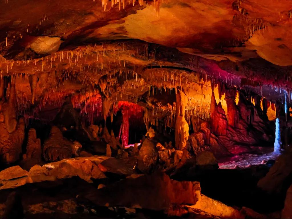 Inner Space Caverns, Georgetown a dark cave illuminated with reds, oranges and yellows.