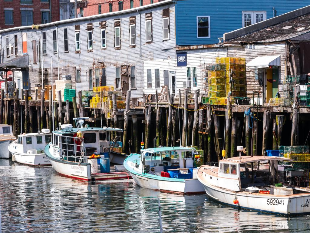 Small fishing boats moored at an old wooden harbor on stilts