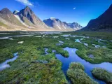 Panoramic view of the rugged Akshayuk Pass, Nunavut, Canada, with a blue sky above
