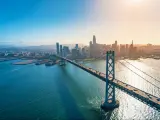 Bay Bridge in San Francisco, CA, USA taken as an aerial view with the city skyline in the distance and taken just as the sun is beginning to set on a clear day.