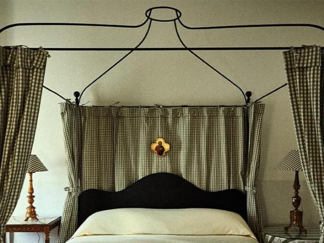Cute bedroom at Hotel Peter and Paul, with green and white gingham iron four-poster bed