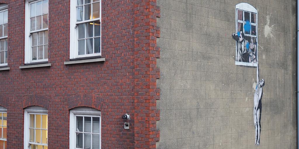 A famous Banksy graffiti on the side of a building in Bristol 