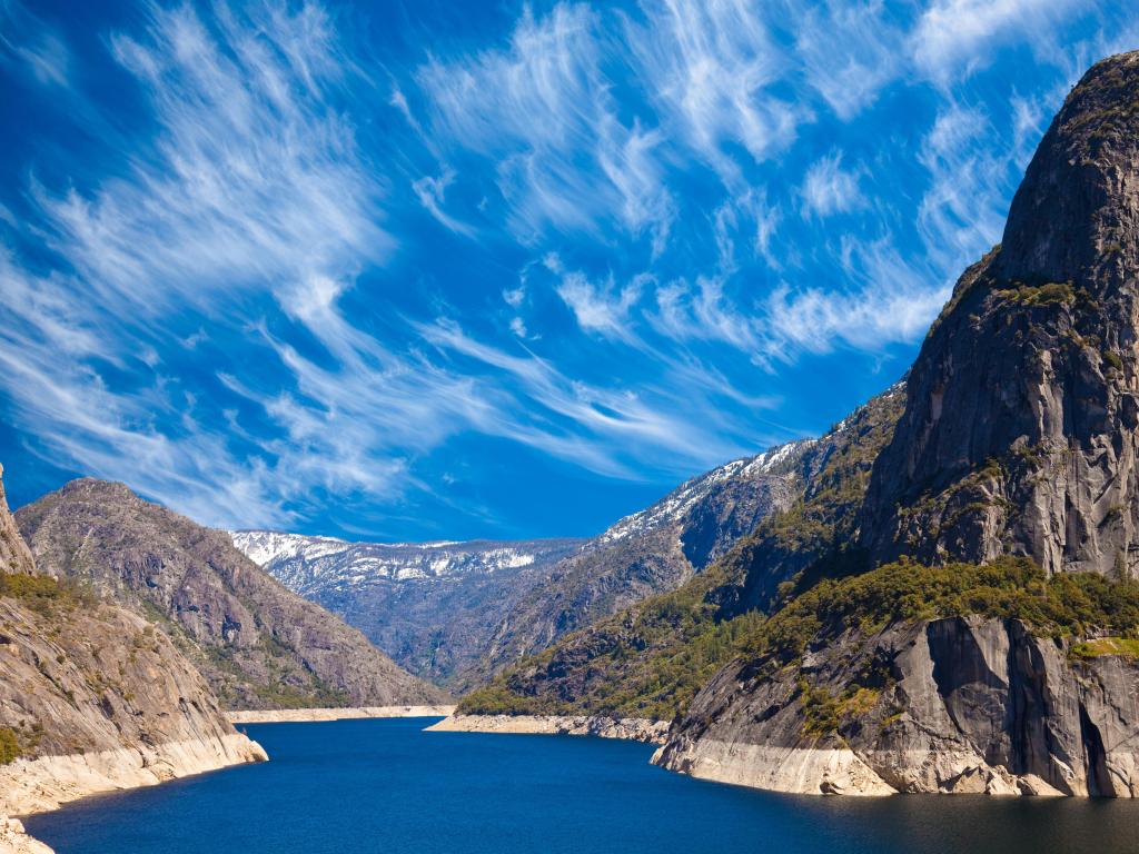 Sunny day with white wispy clouds, looking across Hetch Hetchy reservoir in Yosemite National Park