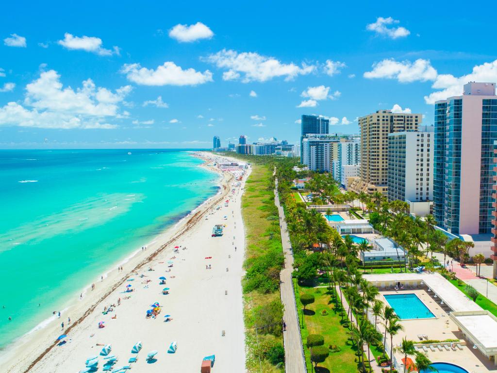 Miami Beach, Florida, USA taken as an aerial view of South Beach with the skyline on the right and the turquoise sea on the left on a sunny day.