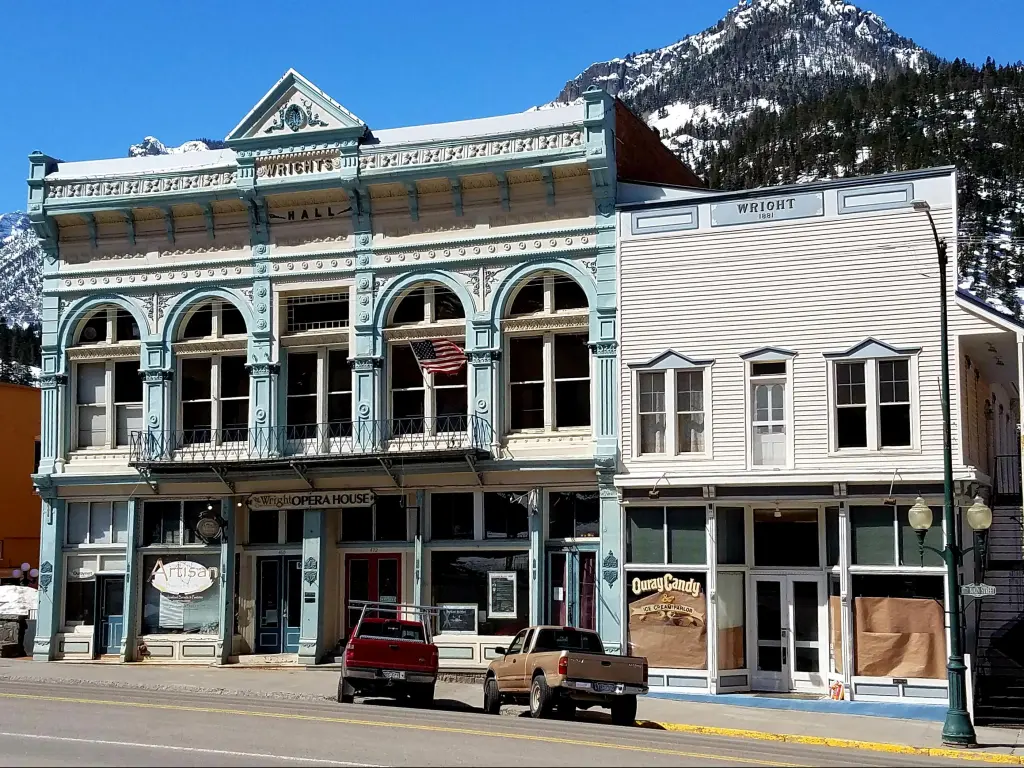 The Historic Wright Opera House, Ouray, Colorado. A beautiful pale blue and white wooden-facade building on a sunny day