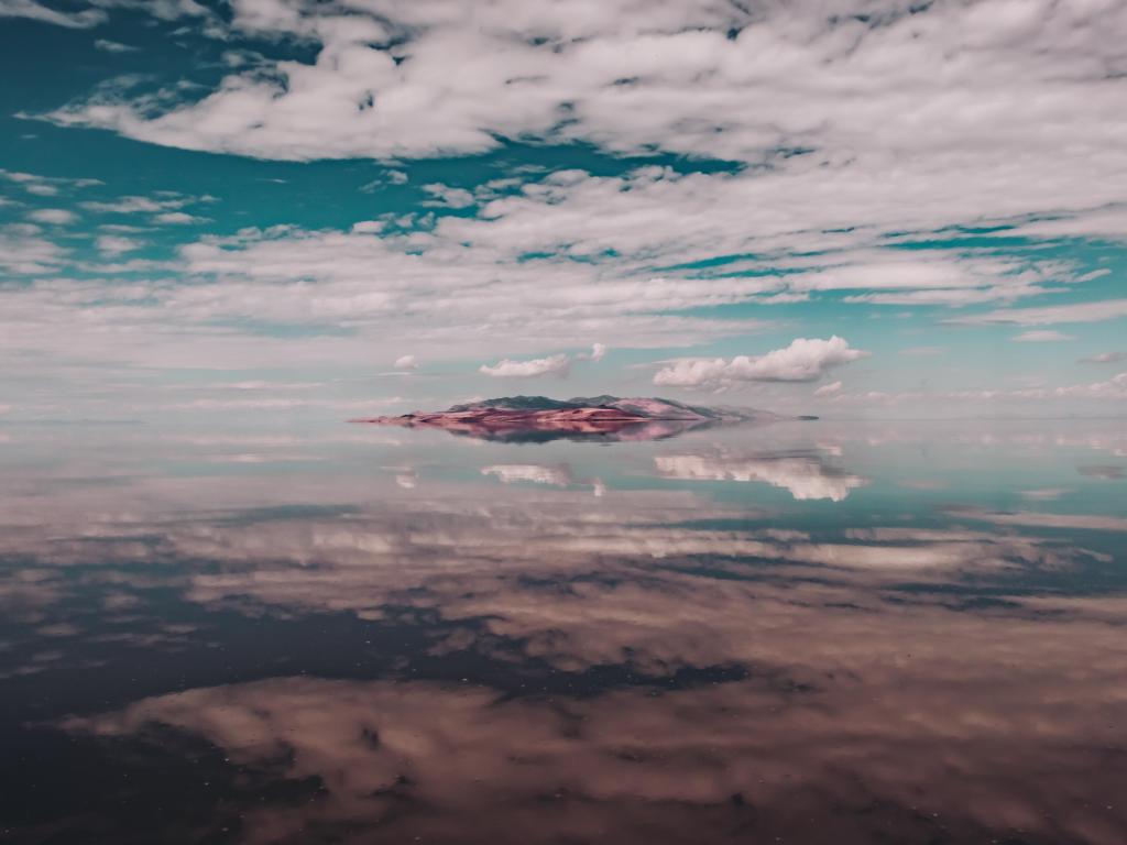 Clouds and mountain reflected in still water of Great Salt Lake