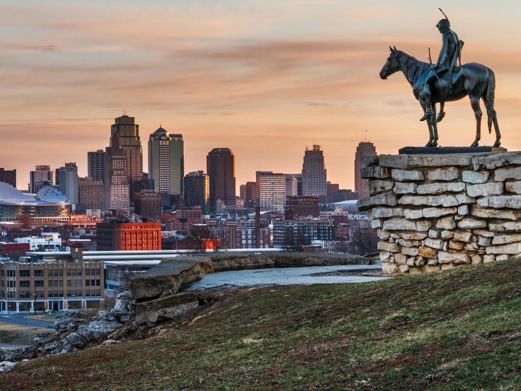 Kansas City, Missouri, USA with an image of the Kansas City Scout overlooking Kansas City at sunrise. The Indian Scout is known as a Kansas City landmark and symbol of the city.