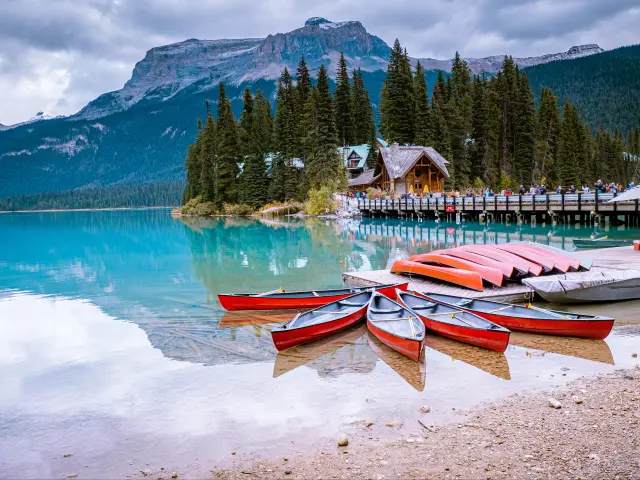 Stunning turquoise waters and mountain backdrop reflected in the waters, with red kayaks tied up along the shoreline, Yoho National Park, Canada