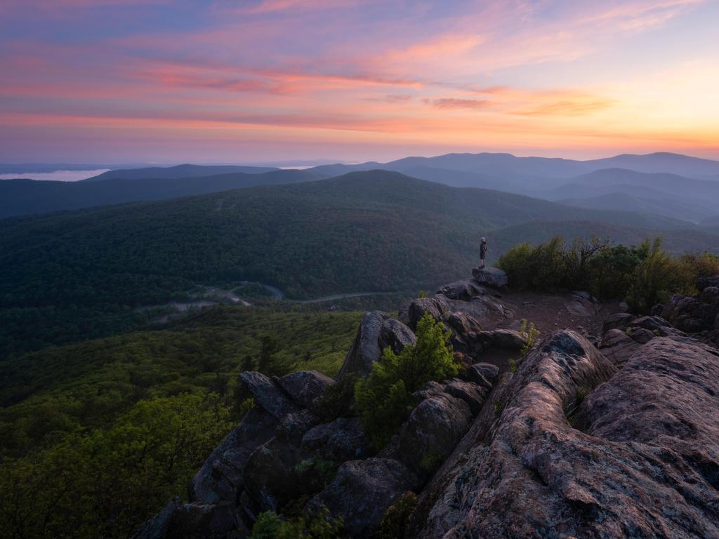 Shenandoah National Park, USA taken at sunrise atop Mary's Rock with a man in the distance overlooking the valleys below.