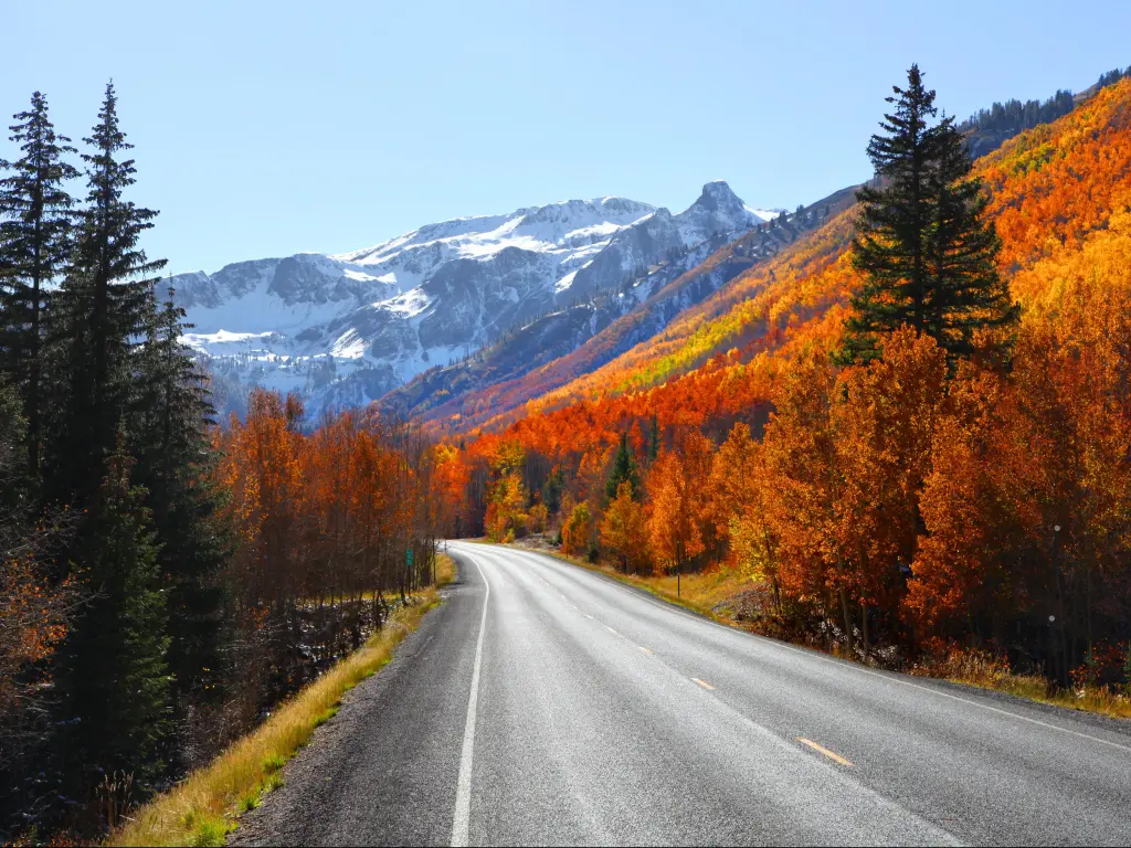 Million Dollar Highway in Colorado with fall foliage and snow capped mountains in the background